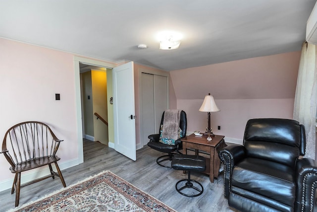 sitting room featuring wood-type flooring and vaulted ceiling