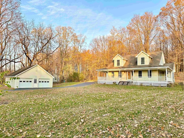 view of front of house with an outbuilding, a front lawn, covered porch, and a garage