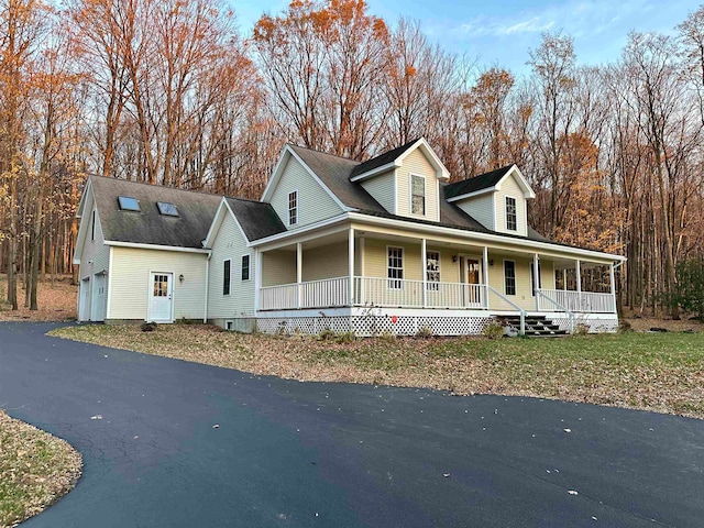 farmhouse-style home featuring covered porch and a garage