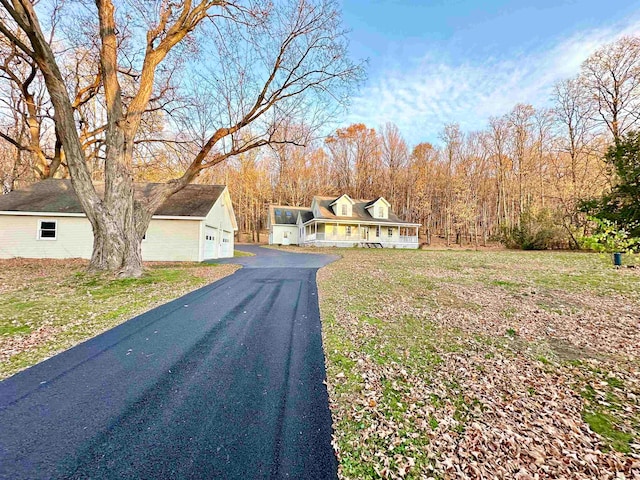 view of front of home featuring an outdoor structure, a front yard, a porch, and a garage