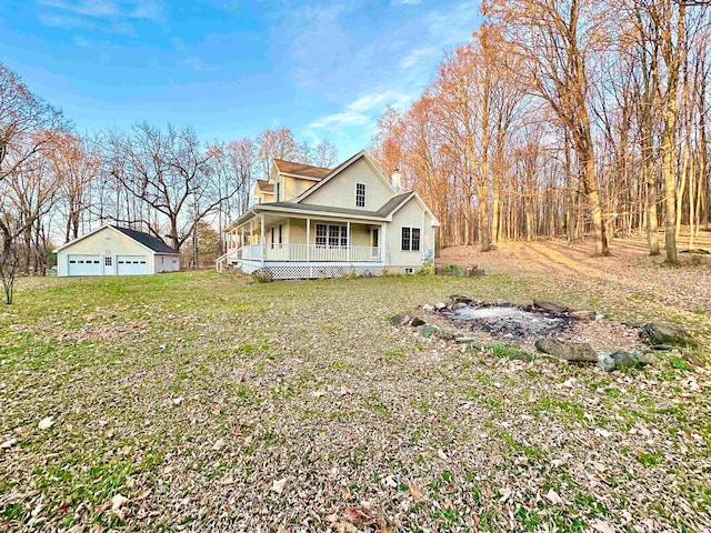 rear view of house featuring covered porch, a garage, and an outdoor structure