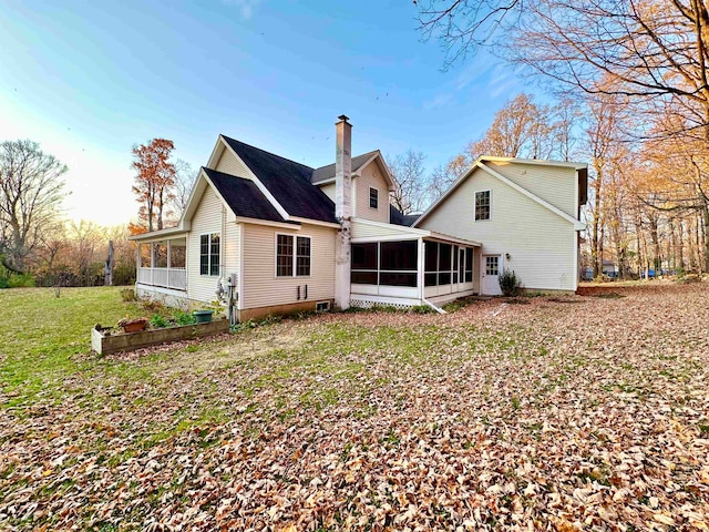 back of property featuring a lawn and a sunroom