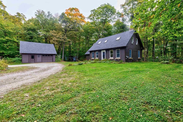 view of front of home with a garage, an outbuilding, and a front lawn