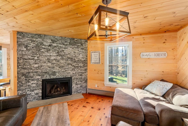 living room with a baseboard heating unit, wooden walls, a fireplace, light hardwood / wood-style floors, and wood ceiling