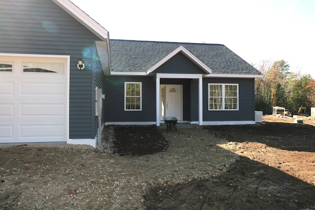 view of front of home with cooling unit and a garage