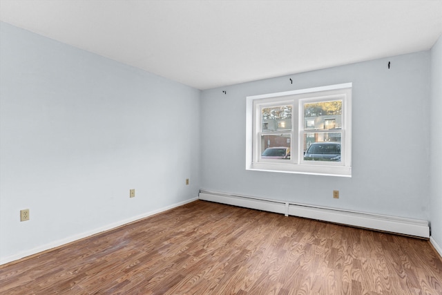 spare room featuring a baseboard radiator and light hardwood / wood-style flooring