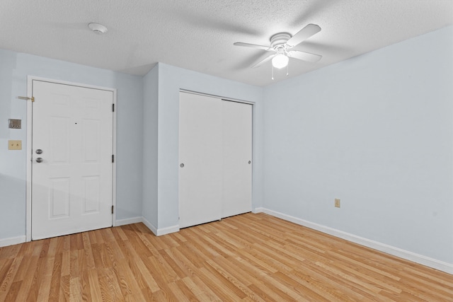 unfurnished bedroom with ceiling fan, light hardwood / wood-style floors, and a textured ceiling