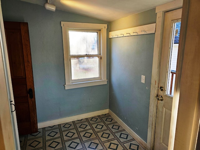 entryway with light tile patterned flooring and vaulted ceiling