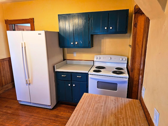 kitchen with blue cabinetry, dark hardwood / wood-style flooring, and white appliances