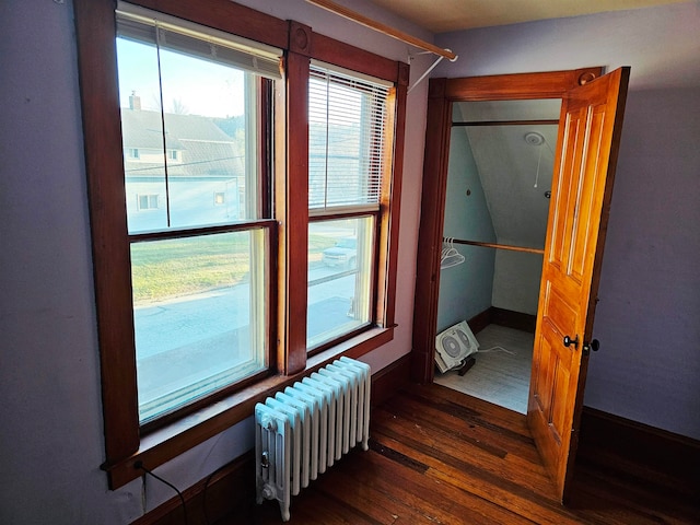 hall featuring radiator heating unit and dark hardwood / wood-style flooring