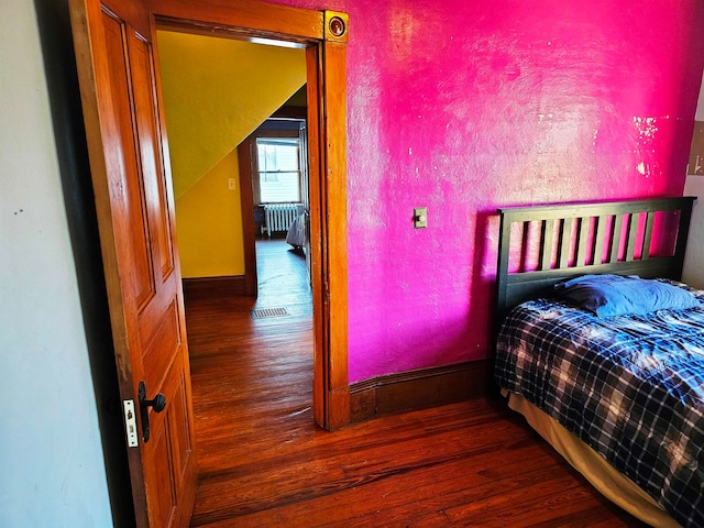 bedroom featuring radiator and dark hardwood / wood-style flooring