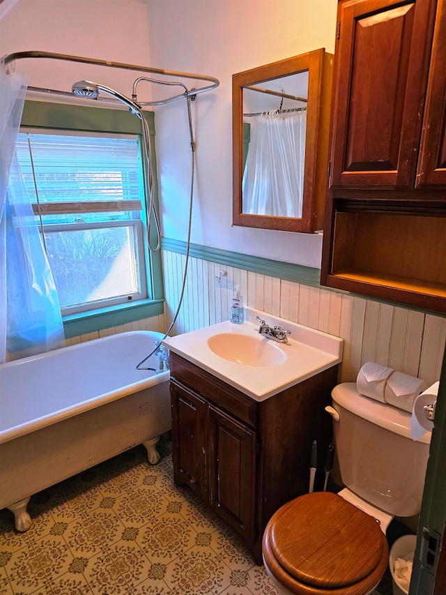 bathroom with a tub to relax in, vanity, and toilet