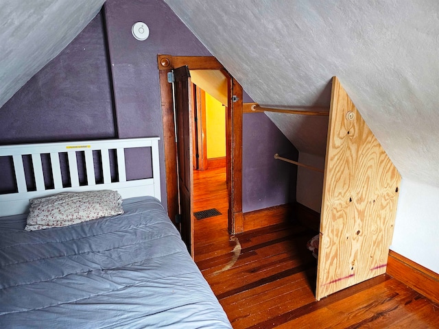 bedroom featuring lofted ceiling and dark hardwood / wood-style floors