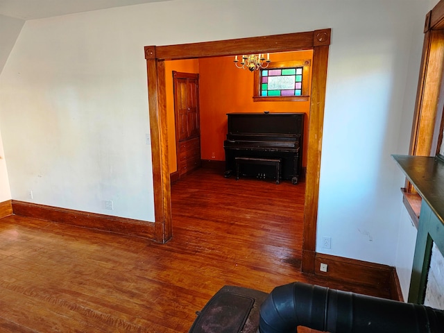 hallway with dark hardwood / wood-style floors and a notable chandelier