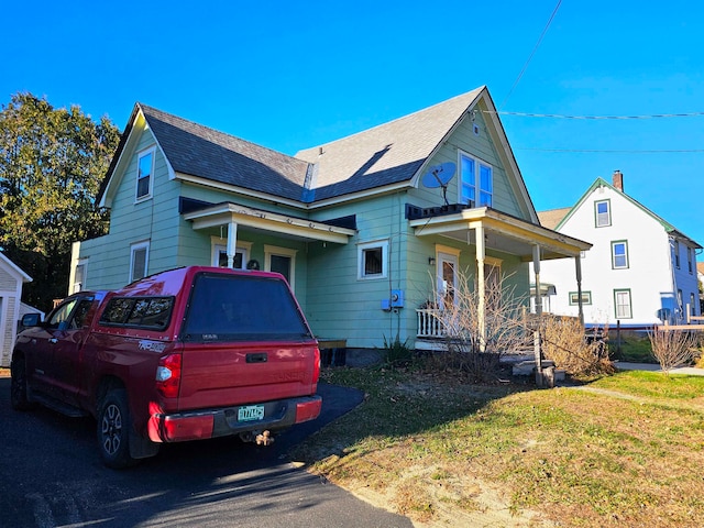 view of front of property featuring covered porch and a front lawn