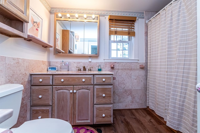 bathroom featuring hardwood / wood-style flooring, vanity, toilet, and tile walls