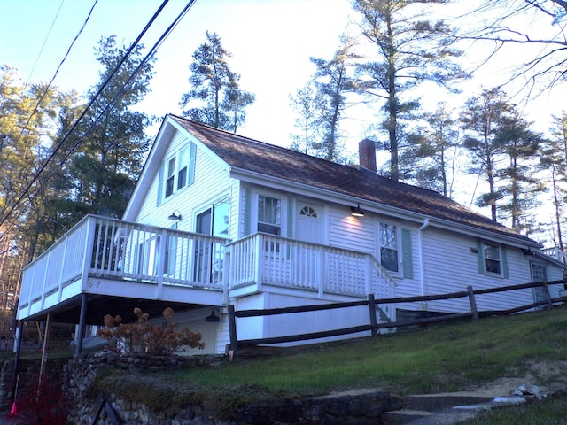 rear view of property with a lawn and a wooden deck