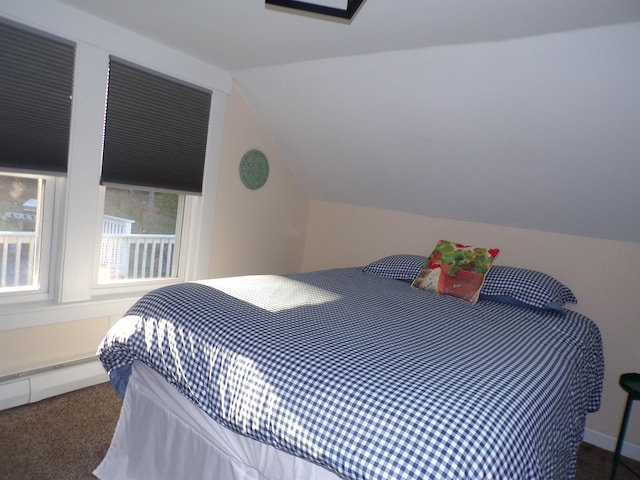 carpeted bedroom with vaulted ceiling and a baseboard heating unit