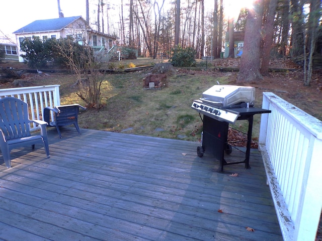 wooden terrace featuring a grill and a yard