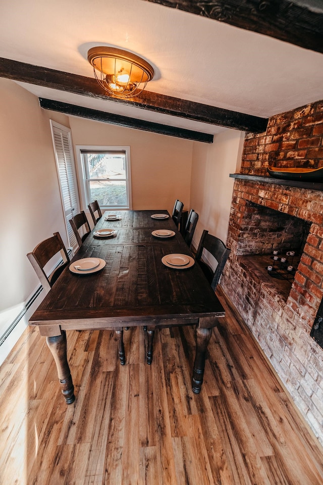 dining space with beamed ceiling and hardwood / wood-style flooring