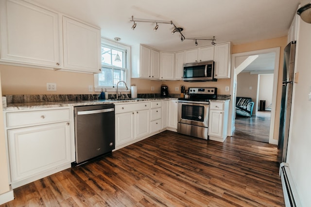 kitchen featuring white cabinets, sink, a baseboard radiator, dark hardwood / wood-style flooring, and stainless steel appliances