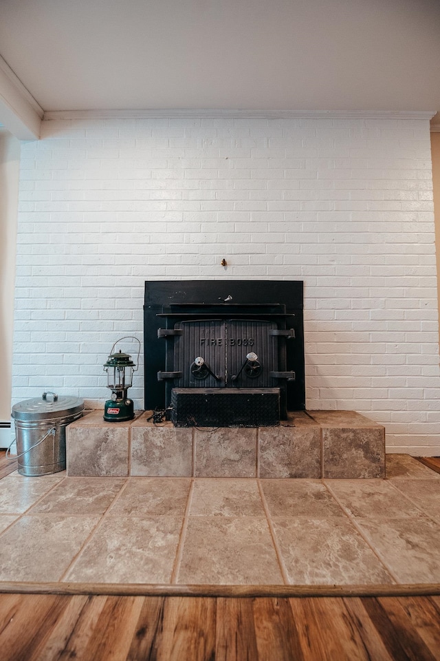 room details with a fireplace, hardwood / wood-style floors, and ornamental molding