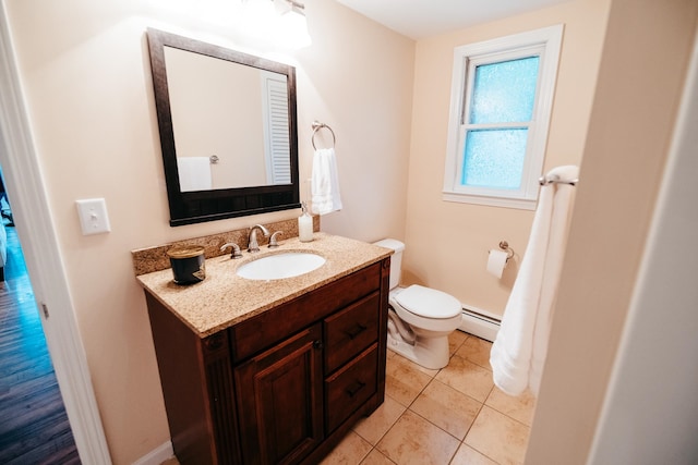 bathroom with tile patterned floors, toilet, vanity, and a baseboard heating unit