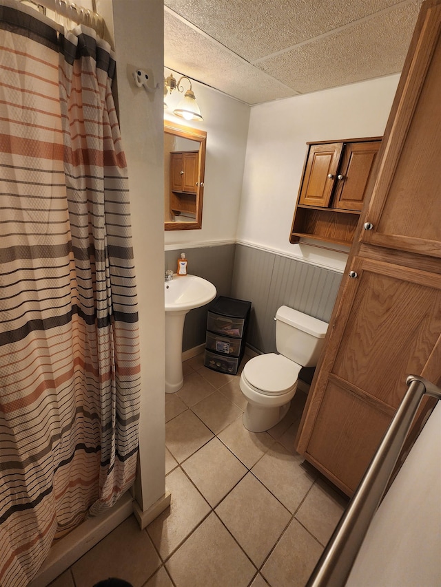 bathroom featuring tile patterned floors, toilet, and a shower with shower curtain