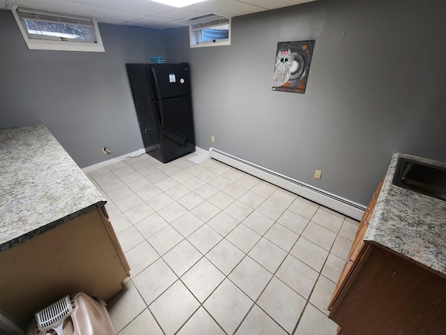 clothes washing area featuring a baseboard radiator and sink