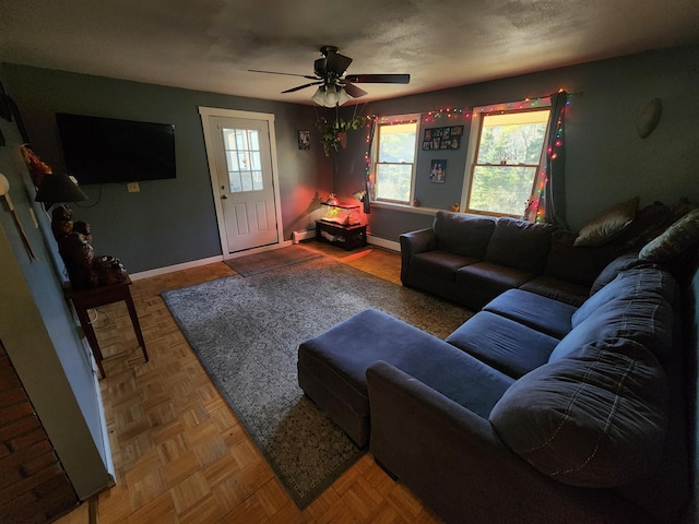 living room featuring parquet flooring, a baseboard radiator, and ceiling fan