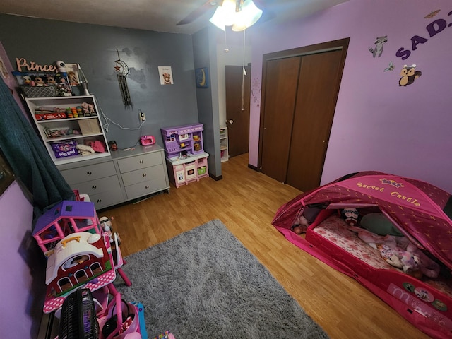 bedroom with hardwood / wood-style flooring, a closet, and ceiling fan