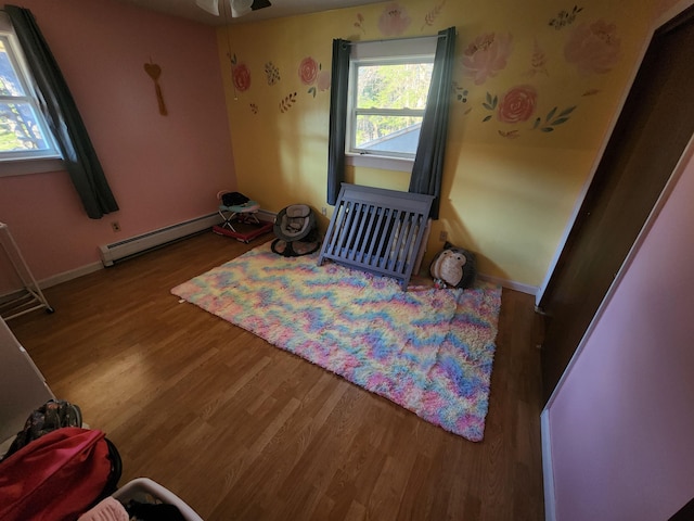 interior space featuring a baseboard heating unit and wood-type flooring