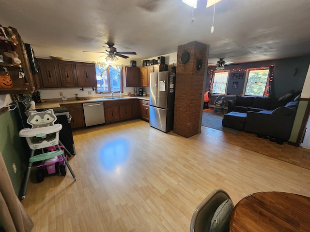 kitchen featuring ceiling fan, appliances with stainless steel finishes, sink, and light wood-type flooring