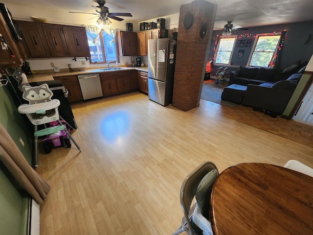 kitchen with sink, light wood-type flooring, ceiling fan, and appliances with stainless steel finishes