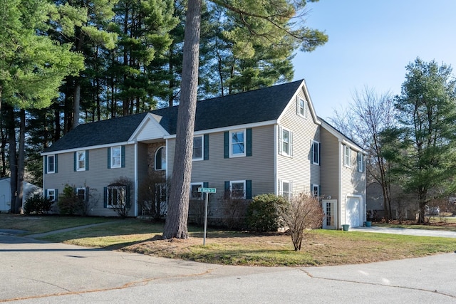 colonial home featuring a front lawn and a garage