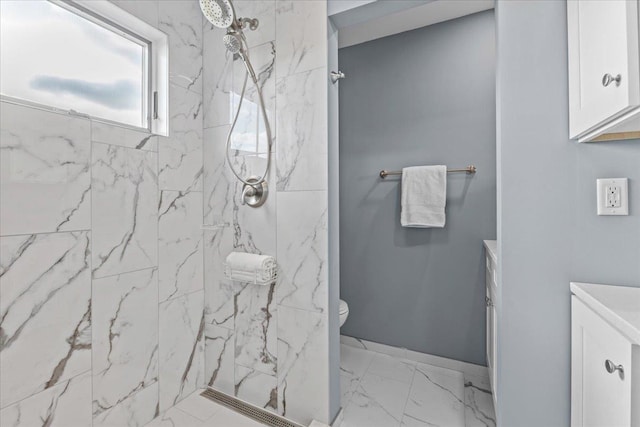 bathroom featuring vanity, toilet, and a tile shower