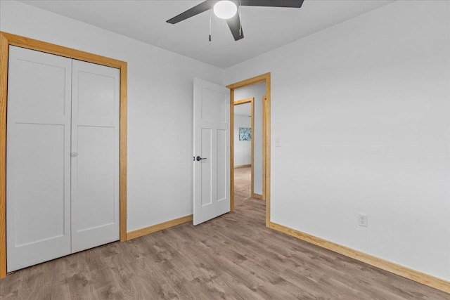 unfurnished bedroom with ceiling fan, a closet, and light hardwood / wood-style flooring