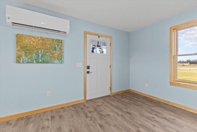 entryway featuring a wall mounted air conditioner and light hardwood / wood-style floors