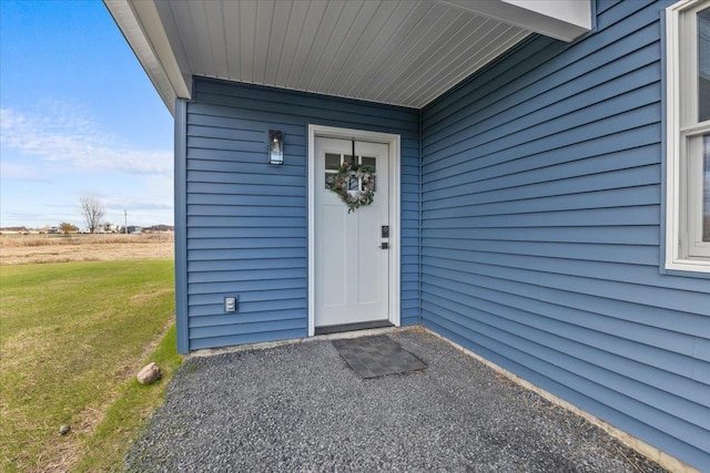 entrance to property featuring a lawn