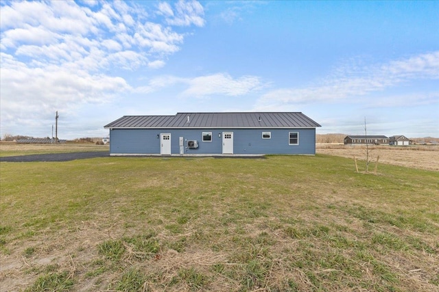 rear view of house featuring a yard