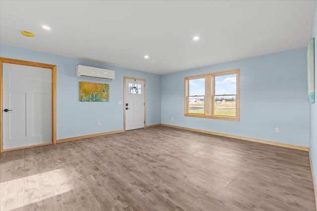 interior space with a wall unit AC and light hardwood / wood-style flooring