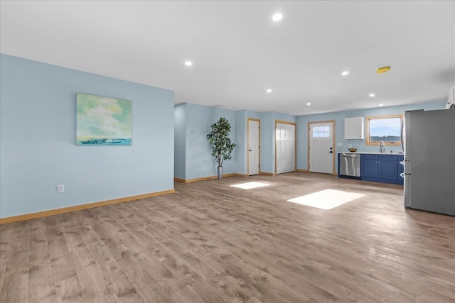 unfurnished living room with sink and light wood-type flooring