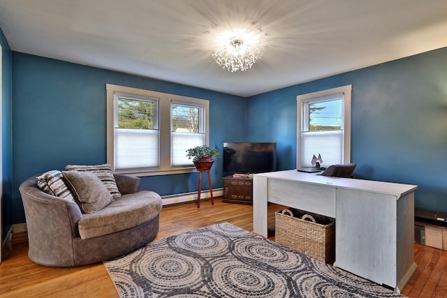 office space with baseboard heating, an inviting chandelier, and hardwood / wood-style flooring