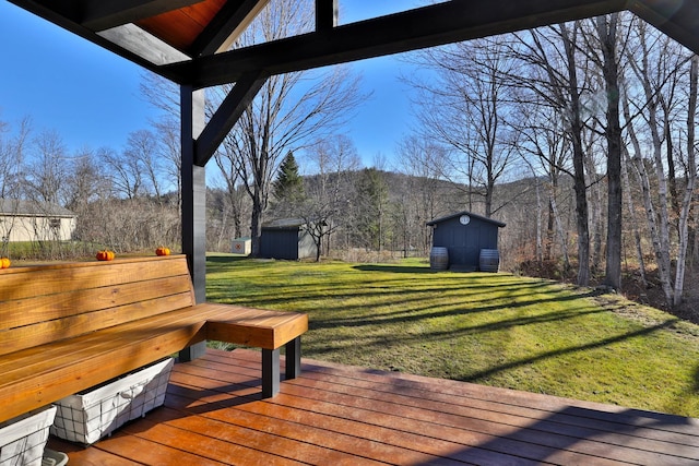 wooden terrace featuring a shed and a yard