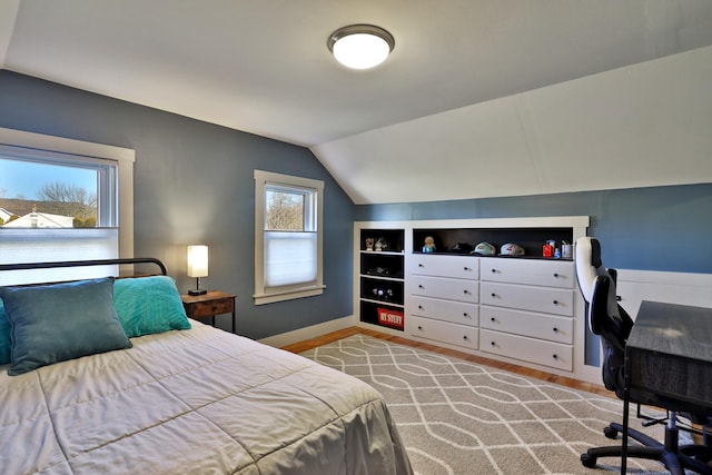 bedroom with multiple windows and lofted ceiling