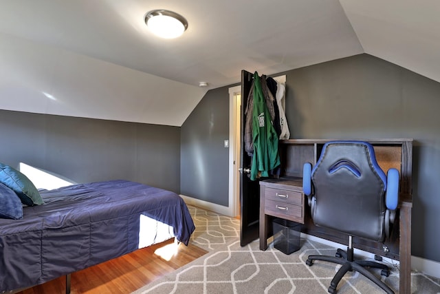 bedroom featuring light wood-type flooring and vaulted ceiling