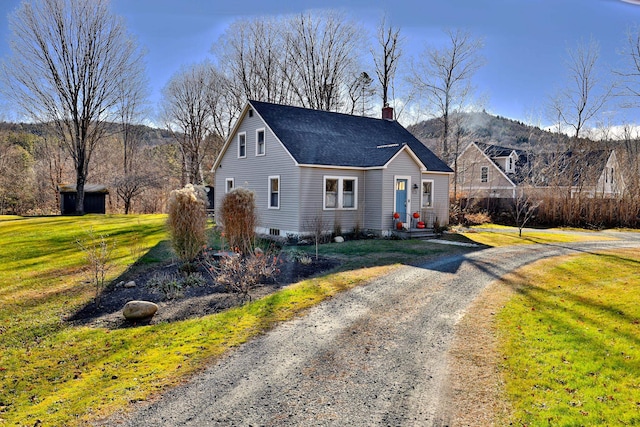 view of front of house with a mountain view and a front lawn