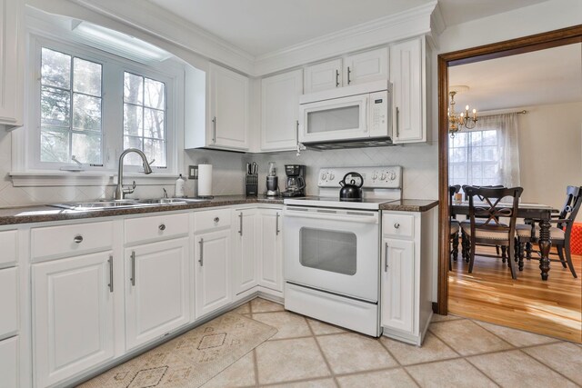 kitchen featuring white cabinets, white appliances, and plenty of natural light