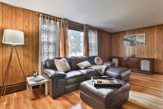 living room with wooden walls and light hardwood / wood-style flooring