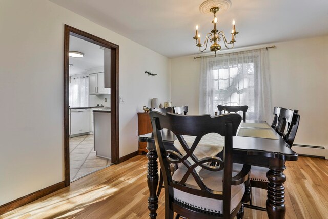 dining space featuring a chandelier, light hardwood / wood-style floors, and a baseboard heating unit